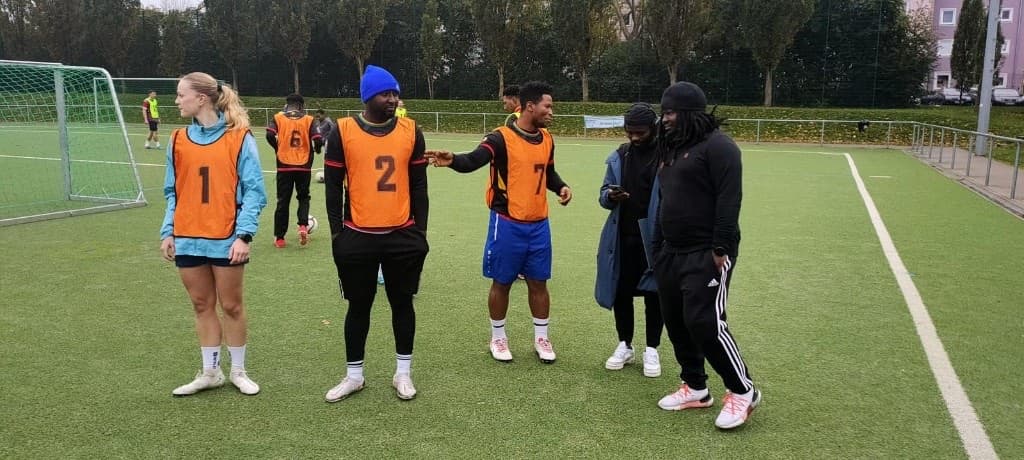 Spielerinnen und Spieler beim Training mit Leibchen auf dem Platz